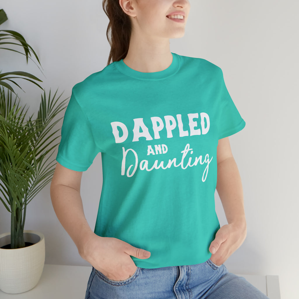 Teal short sleeve with white lettering reading "Dappled and Daunting". 