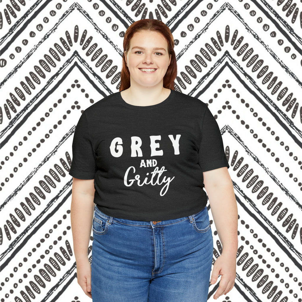 Dark grey plus size short sleeve with white lettering reading "Grey and Gritty". Model wears this with jeans against a black and white southwestern background.