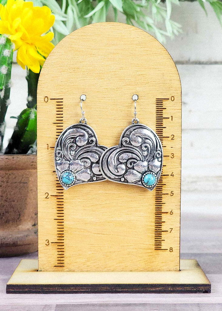 Western cowgirl heart earring antique silver floral design and a turquoise-like stone acting as the middle of flower. Hangs about 2".