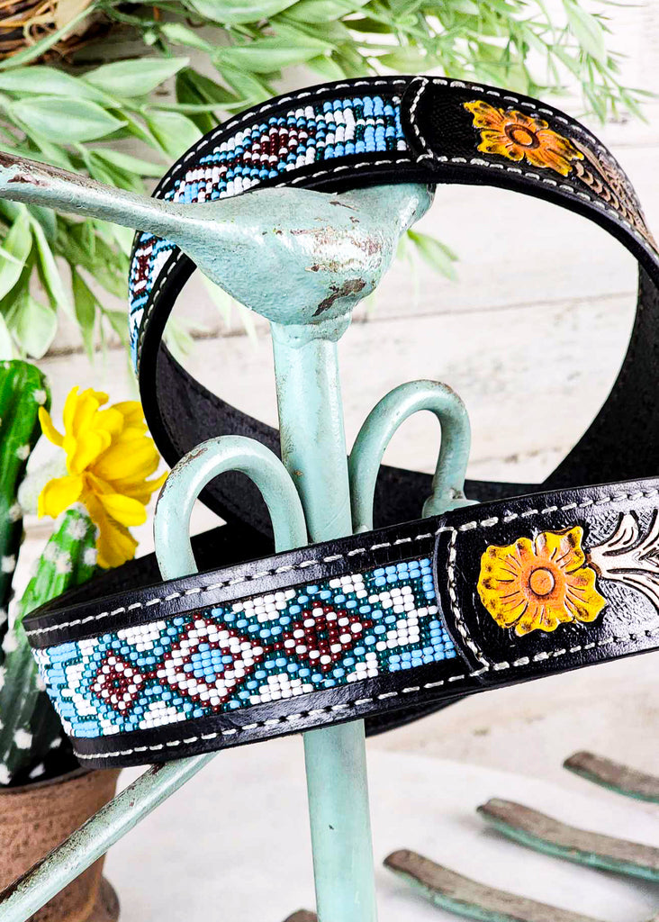Cowgirl style purse strap with floral tooling and teal, red, and white beading.