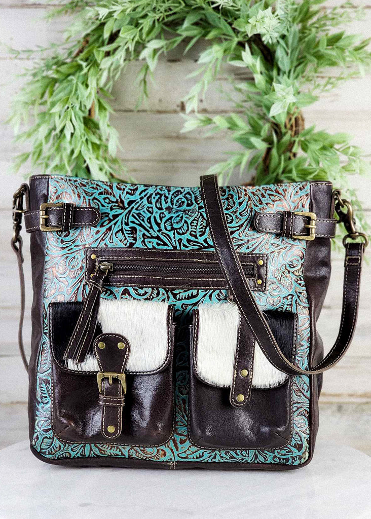 Front view. Turquoise tooled handbag with cowhide pockets. 