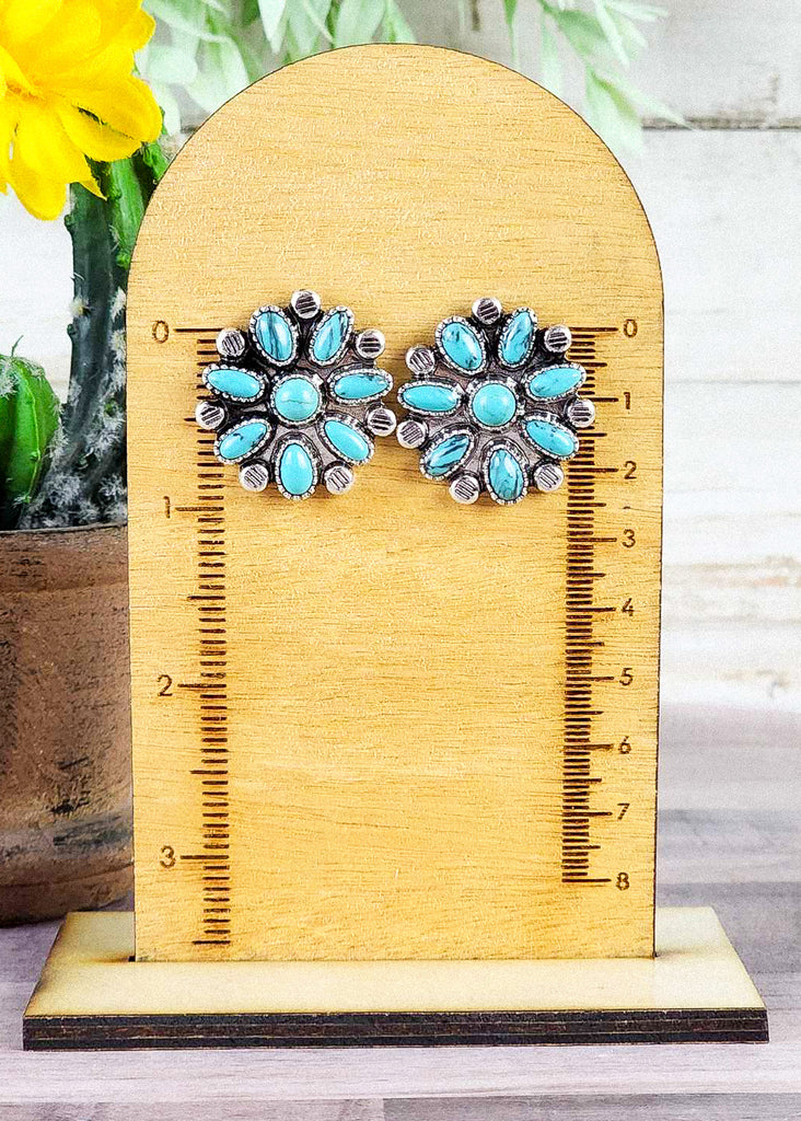 Cowgirl stud earrings with turquoise-like studs set in antique silver in a concho design. About 1 inch. 