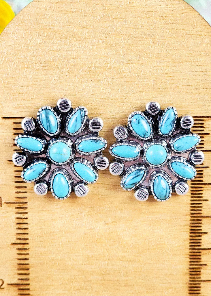 Zoomed in cowgirl stud earring with turquoise-like stones set in antique silver. 