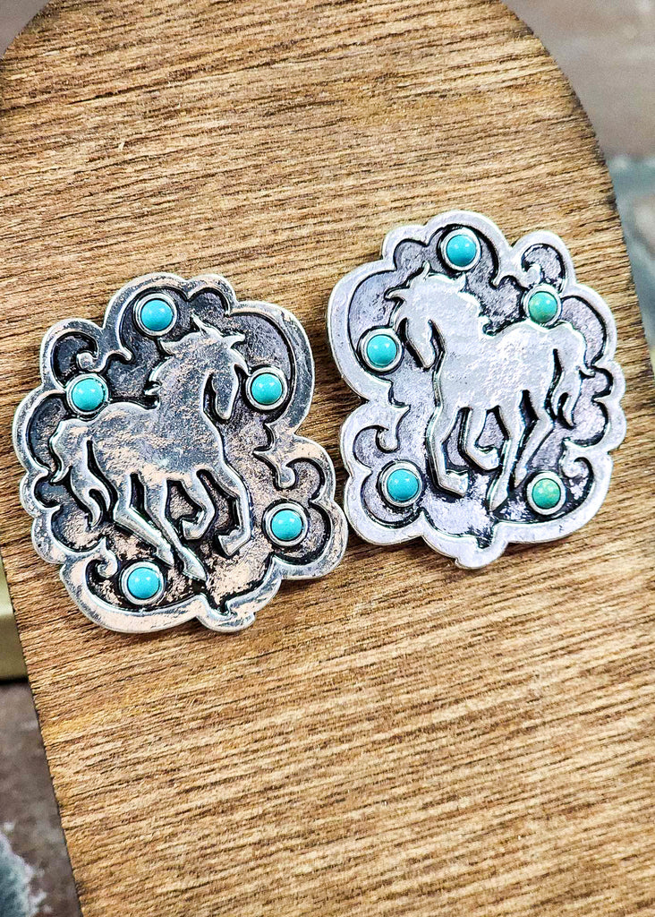 Cowgirl earring with a wild horse running. Five turquoise colored stones are set around the horse in the 'dust' it is kicking up. 