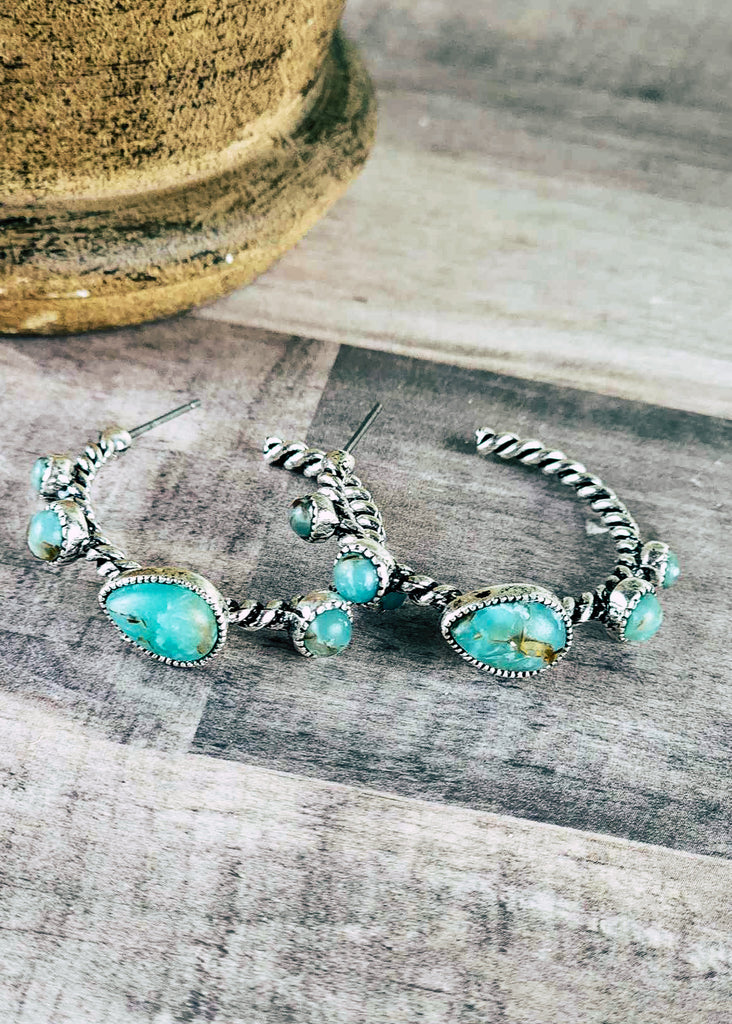 Southwestern style hoop stud earring with five turquoise like stones, four round stones and 1 teardrop stone. Twisted antique silver connects the stones. 