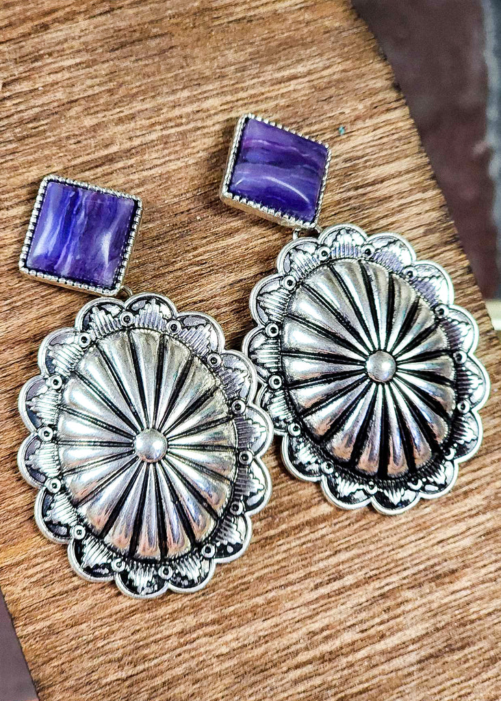 Western antique silver concho stud with purple stone showing the differentiation of coloring in stone. 