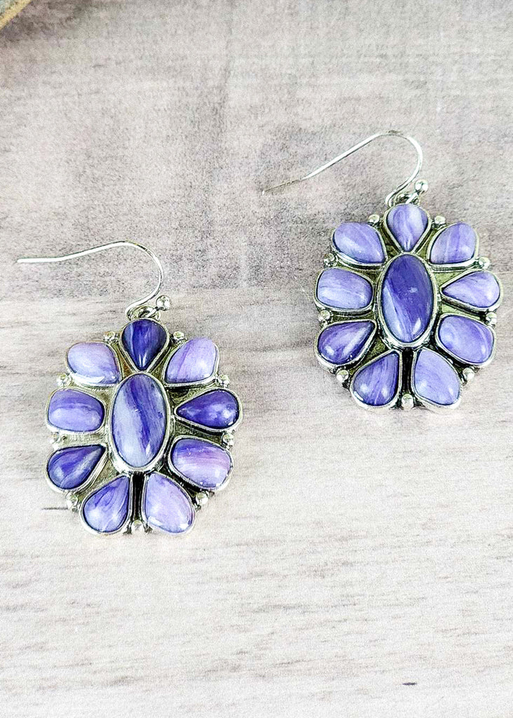 Southwestern concho dangle earrings on wood table.