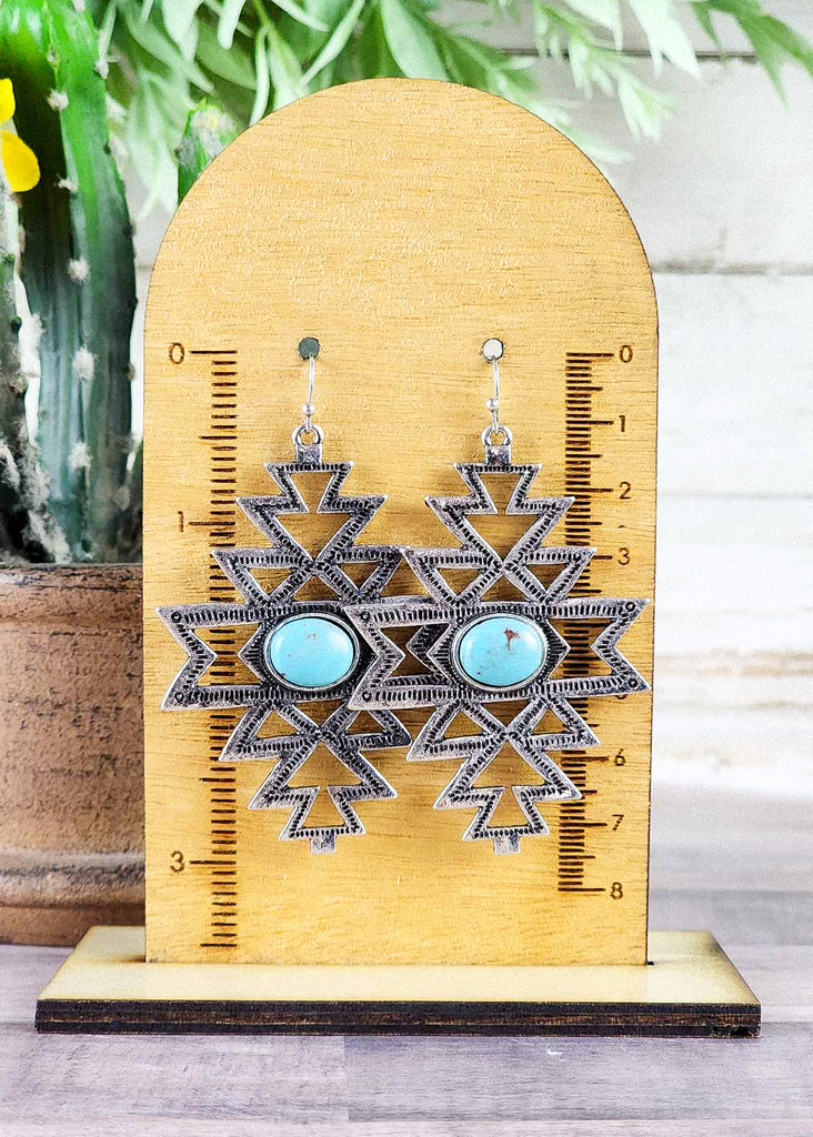 Cowgirl western dangle earrings with an aztec antique silver cut out and a turquoise like stone. 