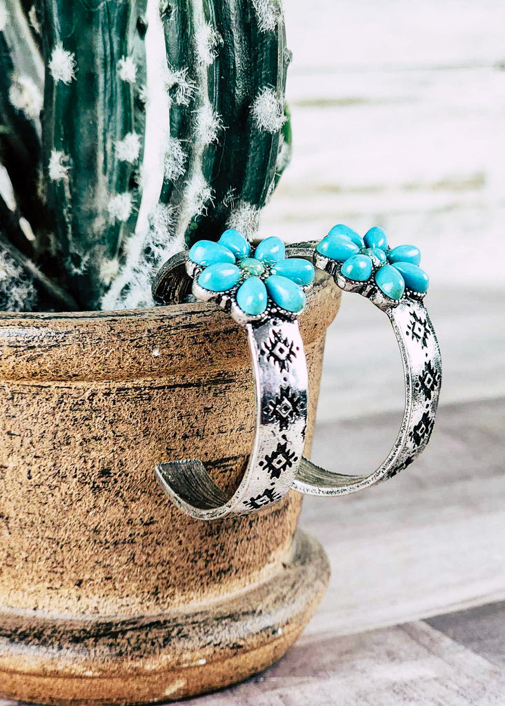 Cowgirl hoop stud earring with floral turquoise like stone design. Antique silver aztec design stamped hoops. Hanging over pot. 