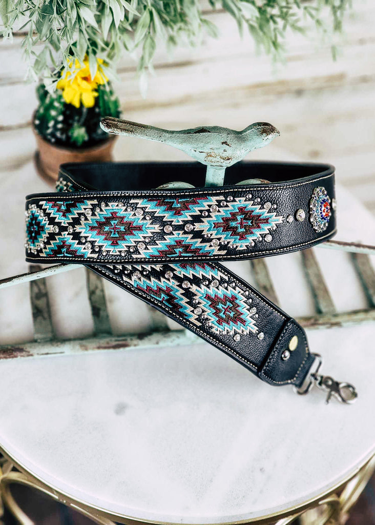Western stitched black & turquoise aztec guitar or purse strap with diamond like jewels throughout the strap. Silver concho with blue, purple, and red jewels. 