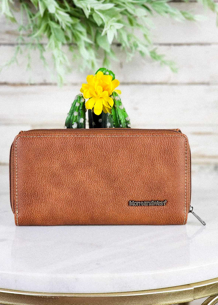 Brown Aztec Thunderbird Embossed Wallet on white table with green cactus decor, western fashion wallet, back view