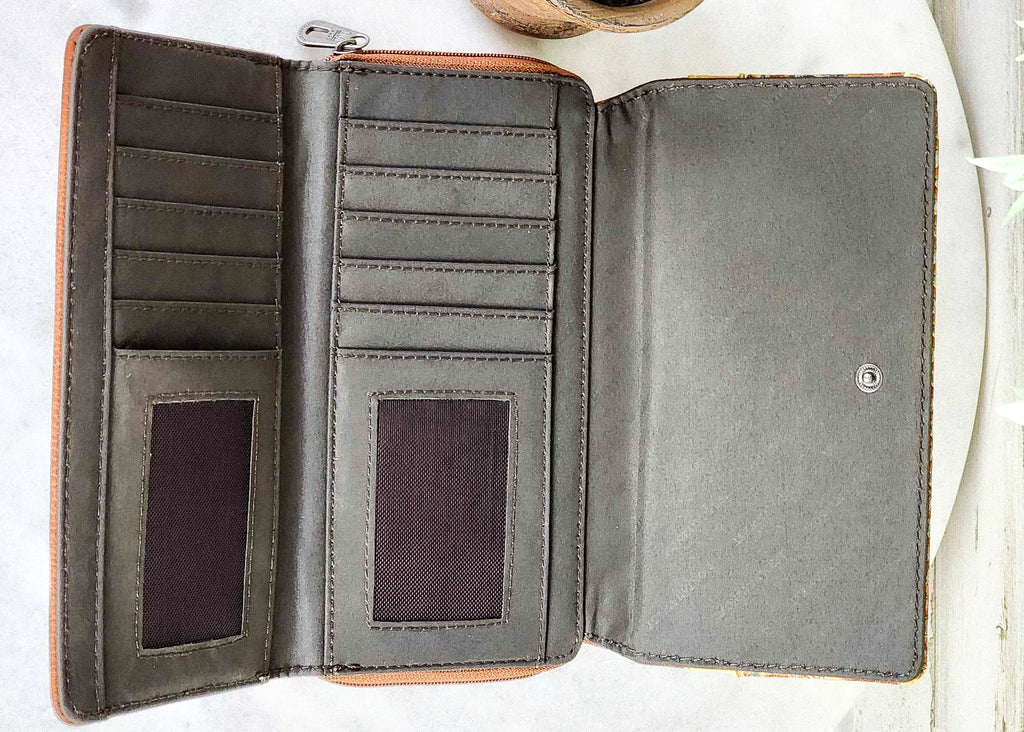 Brown Aztec Thunderbird Embossed Wallet on white table with green cactus decor, western fashion wallet, inside view
