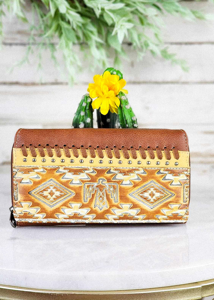 Brown Aztec Thunderbird Embossed Wallet on white table with green cactus decor, western fashion wallet