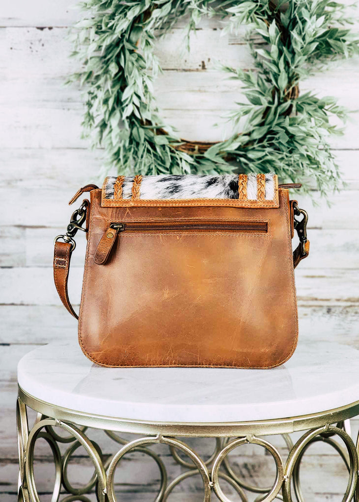 Backside of leather and cowhide purse. Back zippered pocket is visible. 