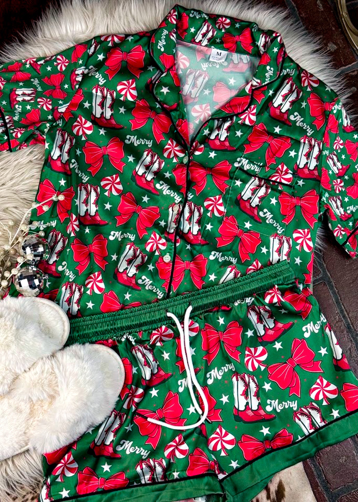green western christmas pajamas with western elements with white fluffy blankets and white slippers
