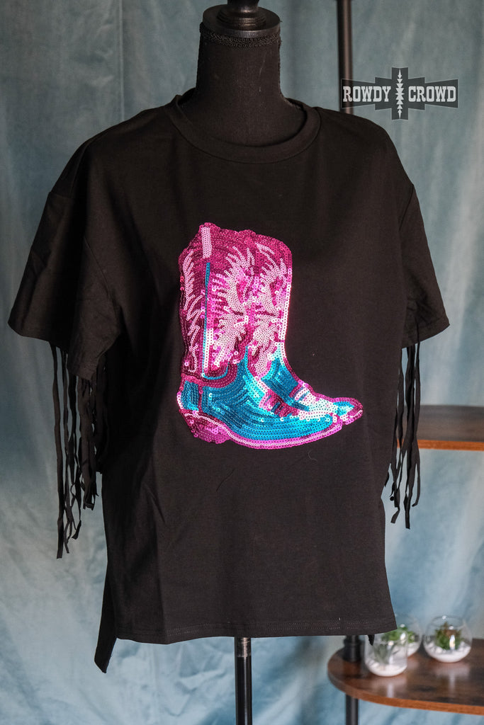 Black short sleeve tee with with a pink and turquoise sequin boot design on front of the tee. Fringe hangs on back of sleeve. Shirt fits loosely on mannequin. 