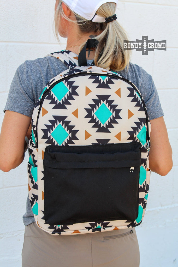 Western backpack with tan canvas and a tribal design with teals and oranges. Black canvas pocket with zipper pocket. Matching canvas for side pockets. 