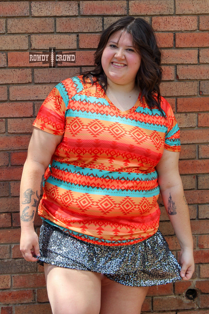 Black sequin shorts with riffles on model up against a brick wall. 