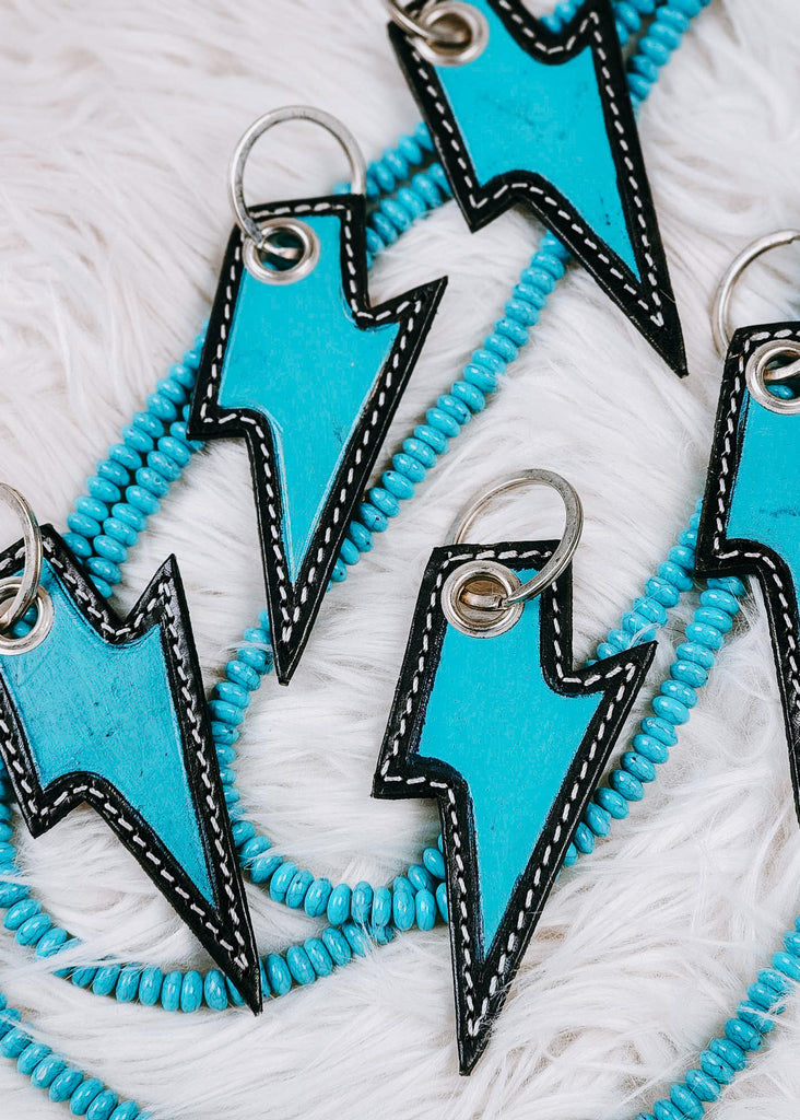 Leather Distressed Turquoise Lightning Bolt Keyring on white fluffy rug with turquoise beads