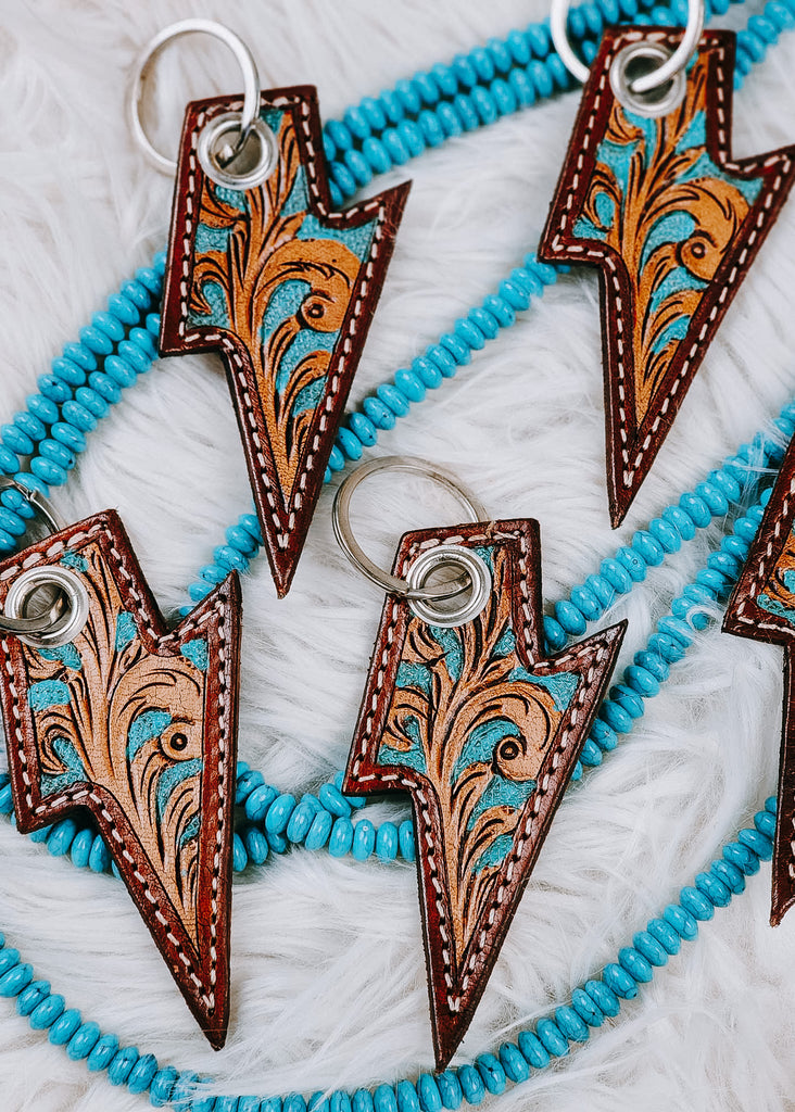 Leather Tooled Lightning Bolt Keyring on white rug with turquoise beads
