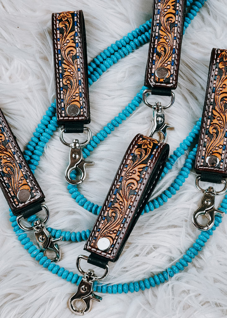 Tooled Floral Leather Keyring on white fluffy rug with turquoise beads