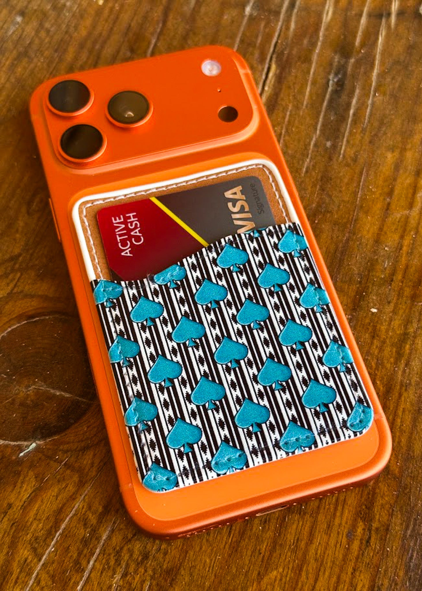 aztec spade card holder on orange phone with wood background