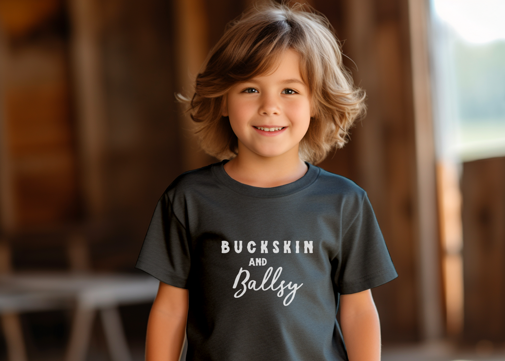 Dark grey youth short sleeve with white lettering reading "Buckskin and Ballsy". 