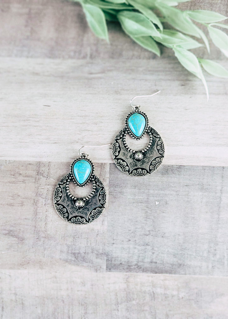 Turquoise & Silver Round Southwestern Earrings on wood background with green decor
