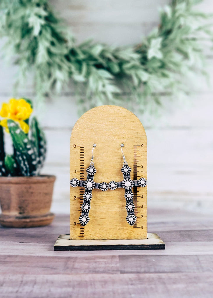 White Western Concho Cross Earrings on wood background hanging on wood measurement stand
