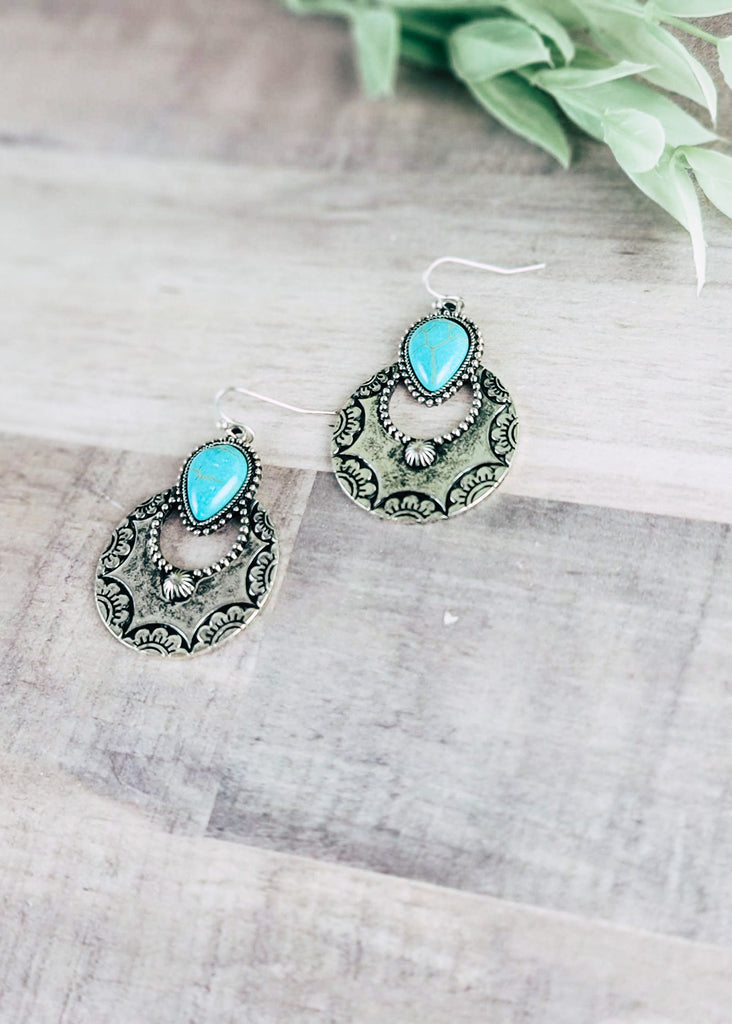 Turquoise & Silver Round Southwestern Earrings on wood background with green decor