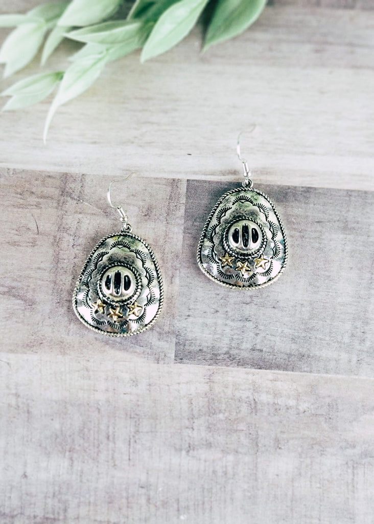 Silver Cowboy Hat Earrings on wood background with green decor