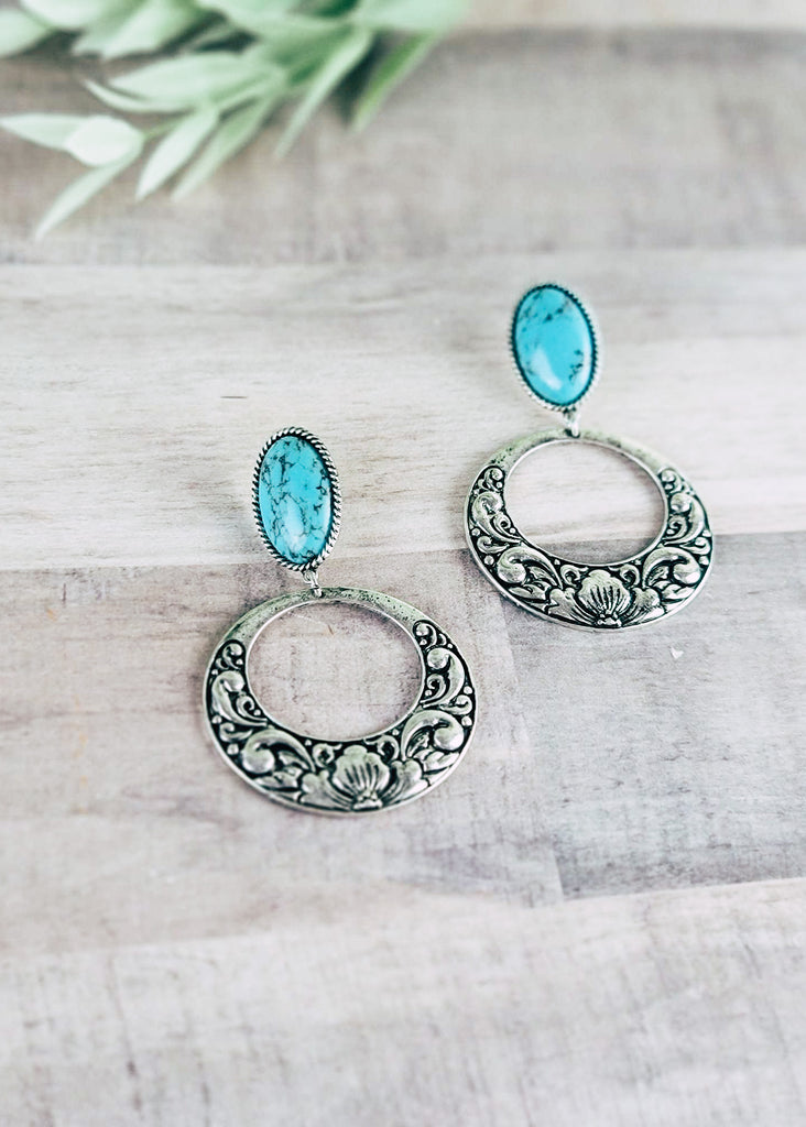 Turquoise Hoop Earrings on wood background with green decor in corner