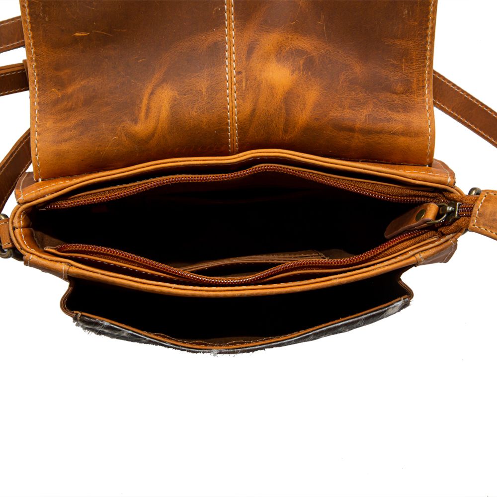 Interior of leather purse with open zippered top pocket and two side pockets visible.