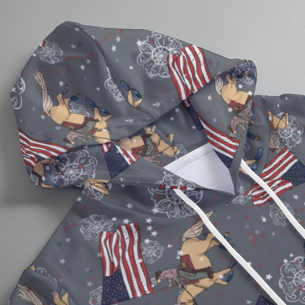 Grey hoodie with Cowboy Christmas with palomino horse and cowgirl running the American flag. Hoodie lays on a flat service. 