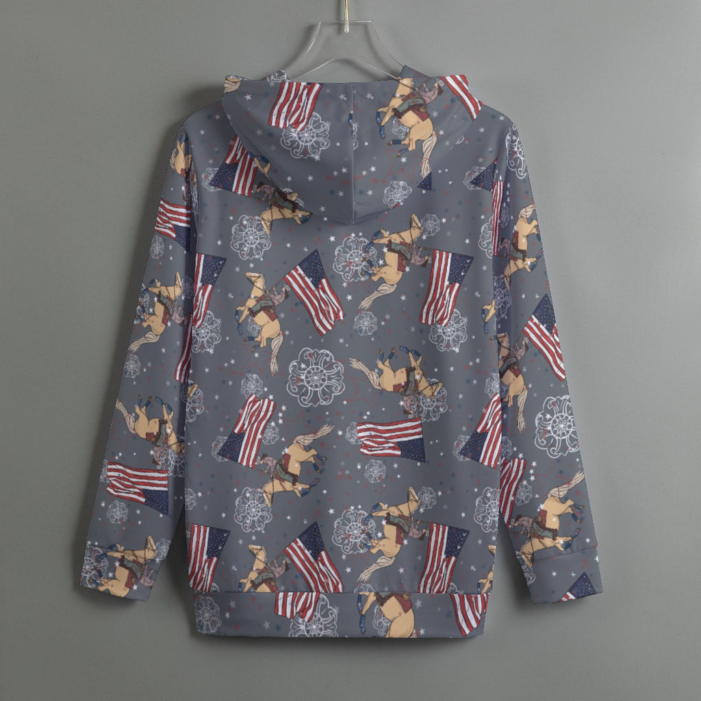 Grey hoodie with Cowboy Christmas with palomino horse and cowgirl running the American flag. Hoodie hangs from a plastic hanger on a grey wall.