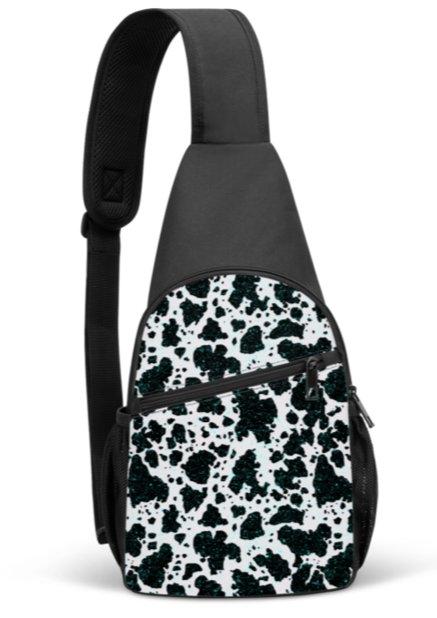 Black sling bag with black and white cowprint and turquoise paint specks. Two zippered pockets and side pockets for water bottle storages. Black adjustable shoulder strap. 