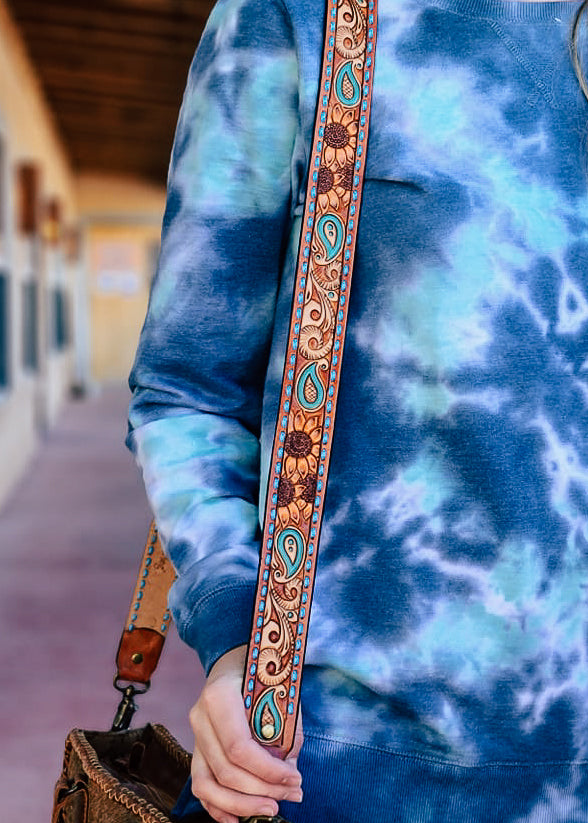 Cowgirl purse strap with sunflower tooling design. Blue buck stitch on the side of the strap, sunflowers and paisley tooling with teal accents. 
