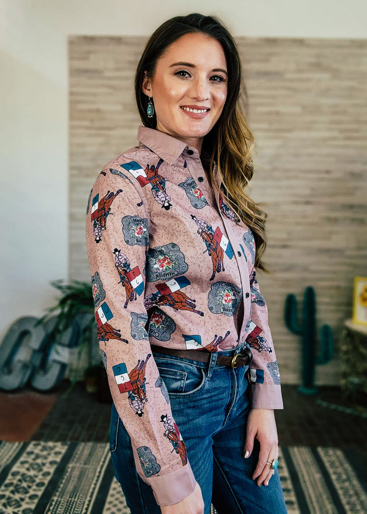 Champagne button down with barrel racer and champion buckle printed on shirt. Model is wearing this with jeans. 