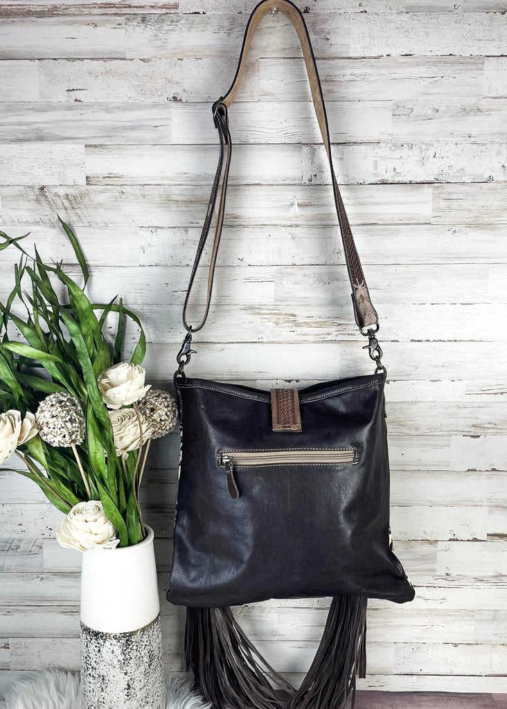 Dark leather backside of purse with zippered pocket. 
