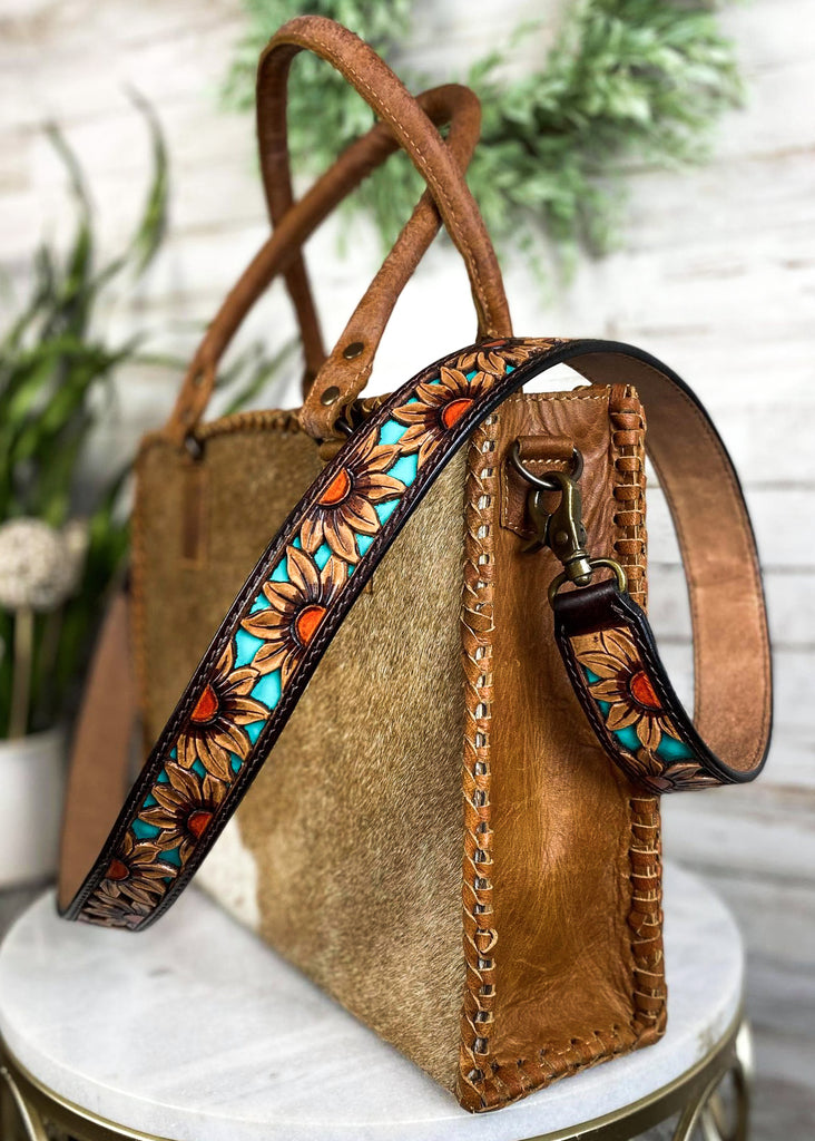 Dusk Sunflower Purse Strap taken on brown cowhide handbag on white table with green floral décor 