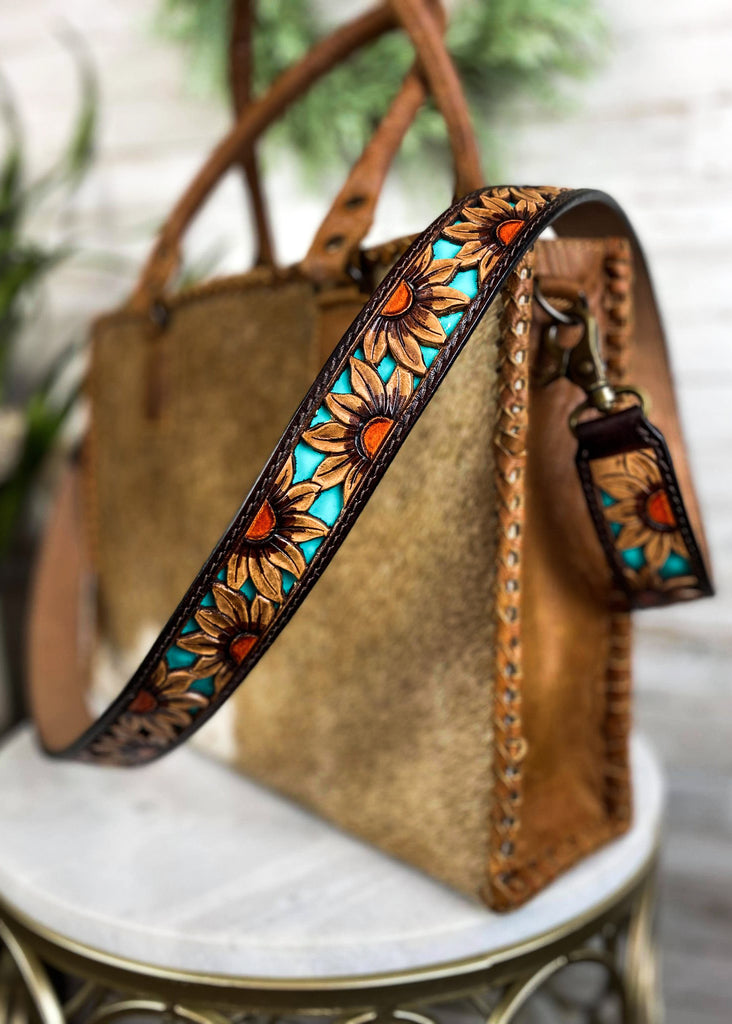 Dusk Sunflower Purse Strap taken on brown cowhide handbag on white table with green floral décor 