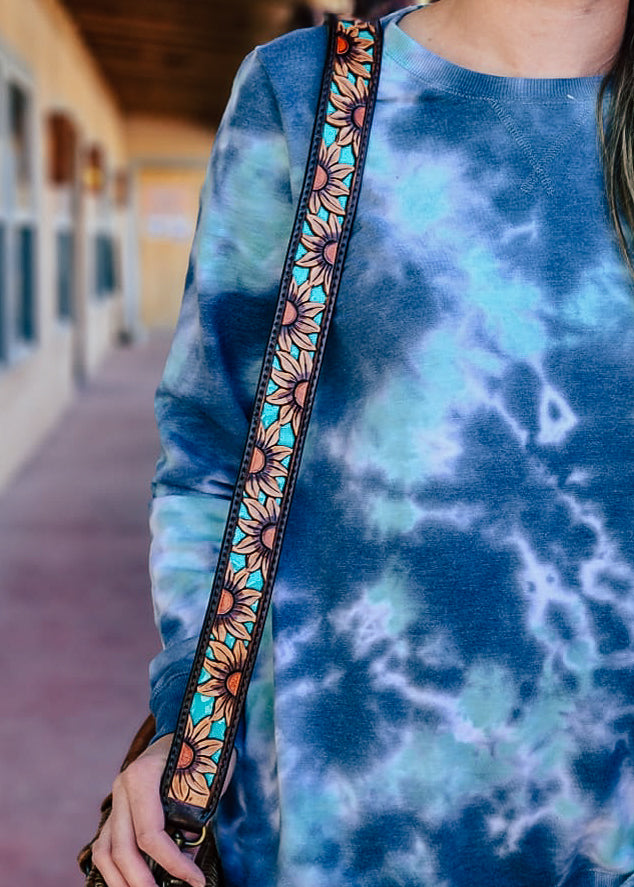 Sunflower tooled purse strap with teal inlay. This purse strap is on a model outside.