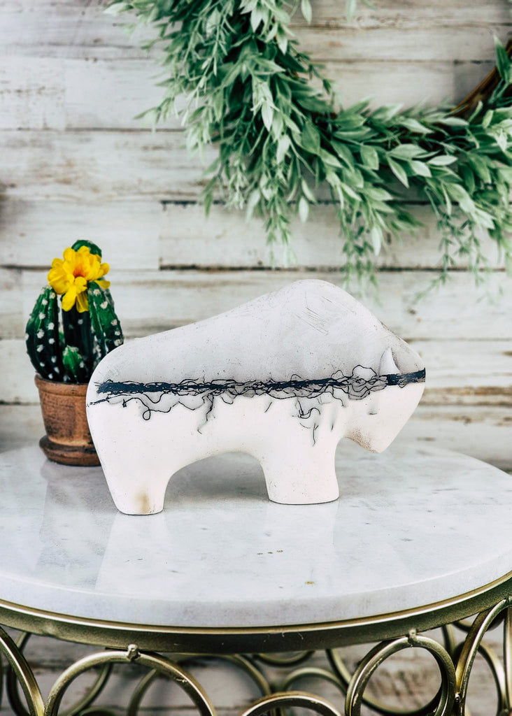Horse hair buffalo with think hair line down the center of the buffalo. Grey top and white bottom are separated by horse hair. The buffalo is displayed on marble table top.
