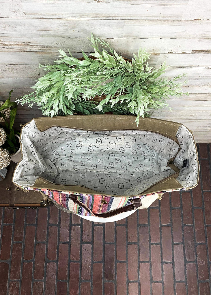 Pastel Hues Aztec Weekender Bag on white table with green decor