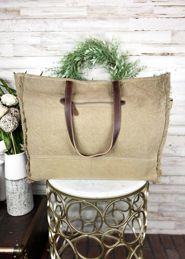 Pastel Hues Aztec Weekender Bag on white table with green decor
