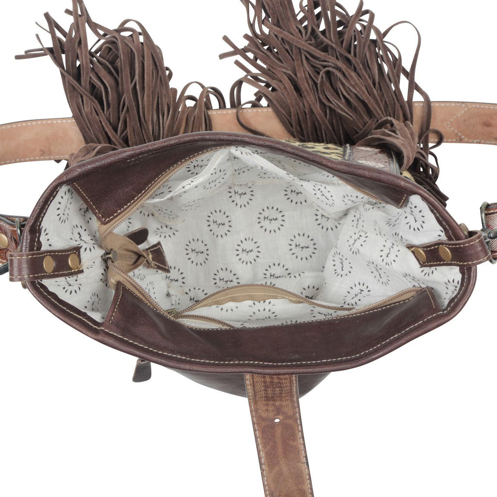 Interior of leather purse with white fabric. Zippered top pocket and zippered side pocket. Three side pockets are visible. 