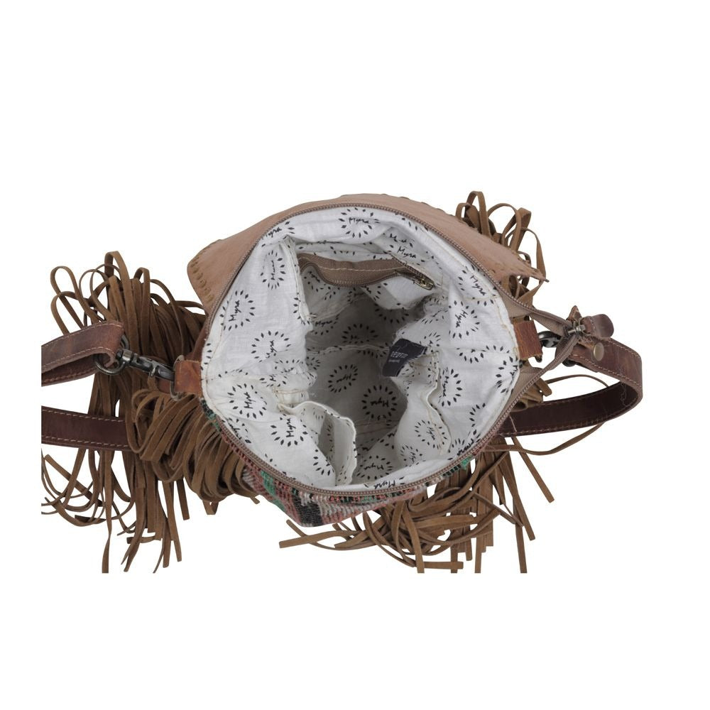 Interior of purse can be see with white fabric liner with zipper and side pockets. 