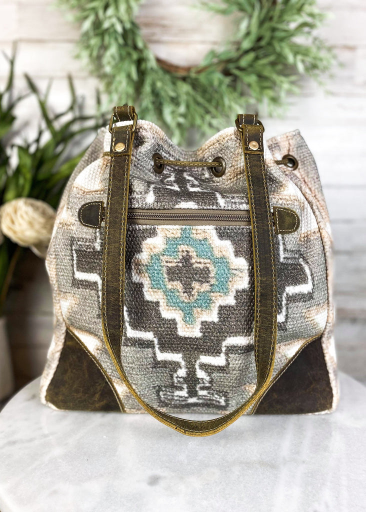 Temple Aztec Bucket Handbag on white table with green decor, back view with zip pocket